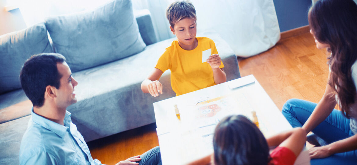 Family playing board game at home.