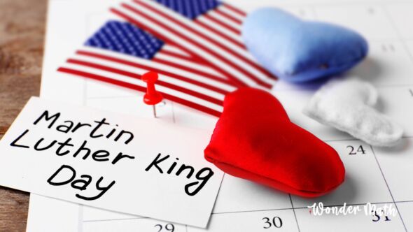 Martin Luther King Jr. Day on a card on top of a calendar with an American flag next to it.